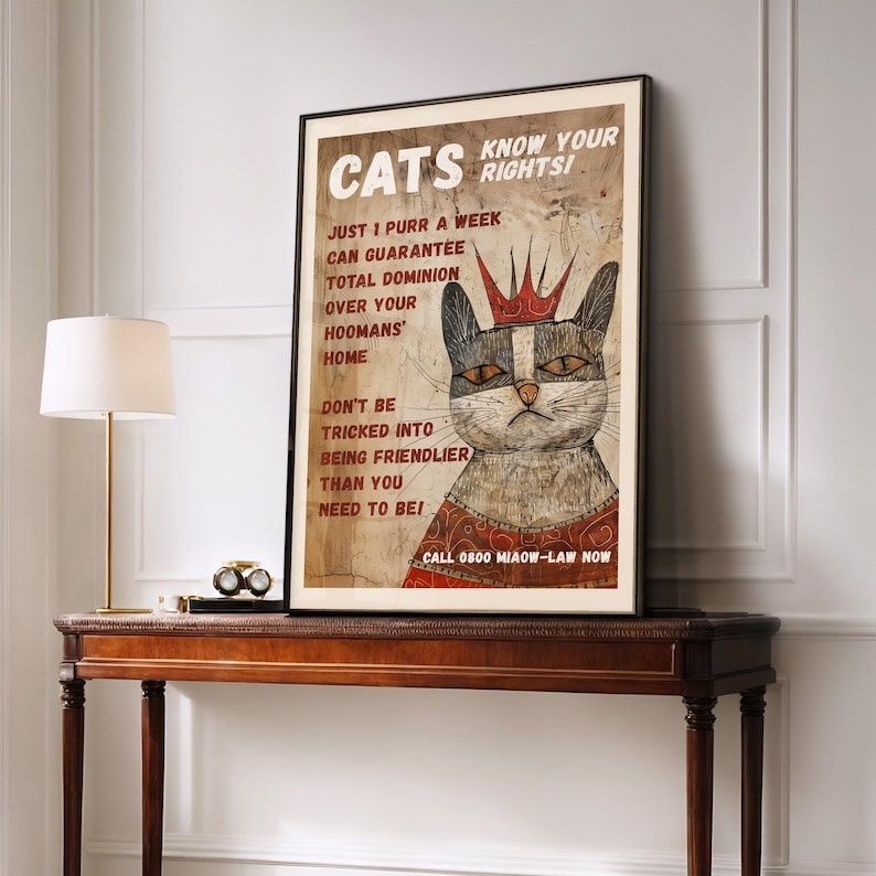 May include: A vintage-style poster with a cartoon cat wearing a crown and a red robe. The poster says "Cats Know Your Rights!" and includes the text "Just 1 purr a week can guarantee total dominion over your hoomans' home. Don't be tricked into being friendlier than you need to be!" and "Call 0800 Miaow-Law Now."