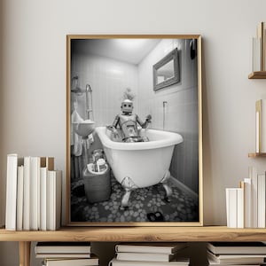 May include: A black and white photo of a robot taking a bath in a white bathtub with claw feet. The robot is sitting in the tub with its arms resting on the edge. The bathroom is tiled in white.