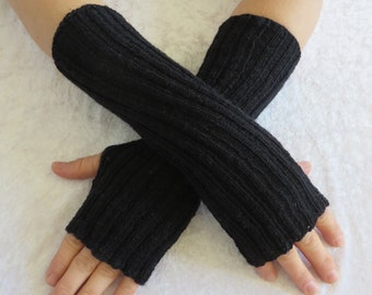 Black wrist warmers made from Regia sock yarn with thumb hole