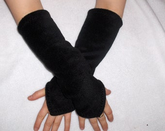 May include: Black fleece arm warmers. These fingerless gloves cover the forearm and have a thumb hole. The arm warmers are made of a soft, plush material. The gloves are designed to keep the hands and arms warm.
