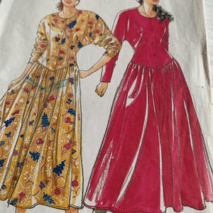 Puede incluir: Patrón de costura Simplicity con dos diseños de vestidos. Un vestido es de manga larga, con botones y estampado floral en amarillo, azul y rojo. El otro es un vestido largo rojo con mangas largas y botones. El número de patrón es 811.
