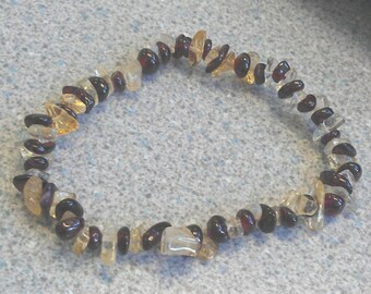 May include: A bracelet made of brown and yellow gemstone beads. The beads are irregularly shaped and have a natural, polished finish.
