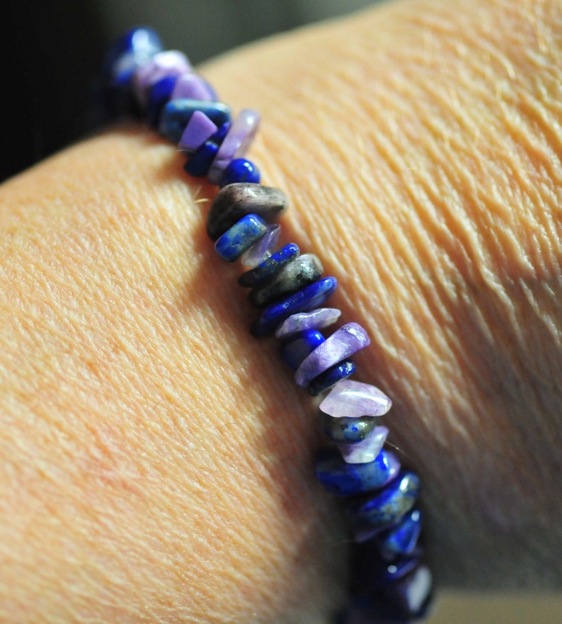 May include: A bracelet made of purple and blue gemstone beads. The beads are irregularly shaped and have a polished finish.