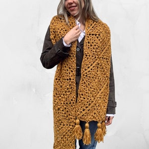 Puede incluir: Una bufanda de crochet de color amarillo mostaza con un borde de flecos y borlas. La bufanda est&aacute; hecha con un patr&oacute;n de punto simple y es un gran accesorio para oto&ntilde;o e invierno.
