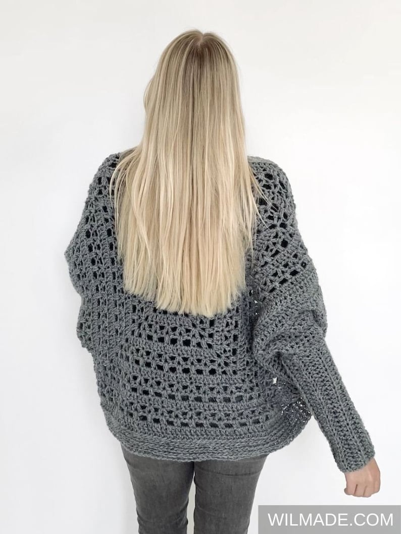 May include: A gray crochet cardigan with a lacy pattern. The cardigan has long sleeves and a loose fit.