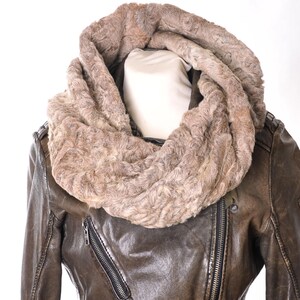 Könnte beinhalten: Eine braune Lederjacke mit einem Kunstfellkragen. Der Kragen ist aus dickem, flauschigem, braunem Fell.
