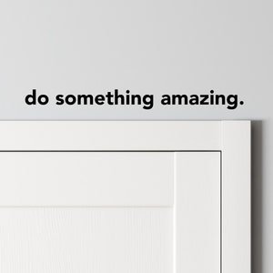May include: White door with a white trim and a black wall decal that reads "do something amazing."
