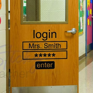 May include: A wooden classroom door with a rectangular glass window and a metal kick plate. The door features black text that reads login, Mrs. Smith, a row of five asterisks, and enter. The door is situated in a school hallway with bulletin boards.