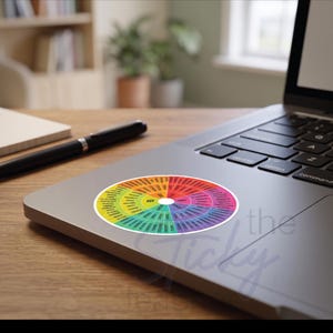 May include: A circular sticker featuring a colorful emotion wheel chart with a white center. The wheel is divided into segments of yellow, orange, red, pink, purple, blue, and green, each containing various emotion labels radiating from the center.