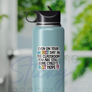 Peut inclure: Une bouteille d'eau bleu clair avec un autocollant qui dit "M&ecirc;me lors de votre pire journ&eacute;e en classe, vous &ecirc;tes toujours le meilleur espoir d'un enfant".