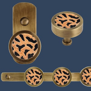 May include: Set of four antique brass cabinet knobs with a leopard print design. The knobs are round and have a raised edge. The leopard print is in shades of brown, black, and white.
