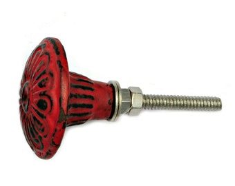 May include: Red metal cabinet knob with a decorative floral design and a silver screw.