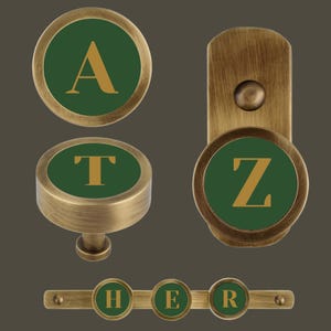 May include: Set of four brass knobs with green and gold accents. The knobs feature the letters A, T, Z, and H, E, R.