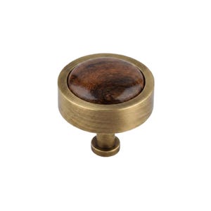 May include: A round cabinet knob featuring a brushed antique brass metal frame and a circular dark brown wood grain inlay. The knob has a cylindrical base and a smooth, polished finish on the wood center, contrasting with the metallic edge.