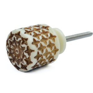 May include: White and brown patterned cabinet knob with a silver screw.
