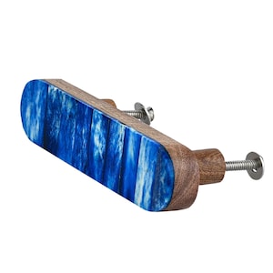 May include: A cabinet pull with a rectangular blue and white marbled center and rounded wooden ends. The hardware includes a silver screw and washer for installation. The pull is designed for furniture and home decor.