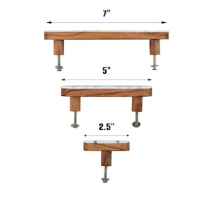 May include: Three cabinet pulls made of brown wood with white and blue marble-like tops. The top pull measures 7 inches, the middle pull measures 5 inches, and the bottom knob measures 2.5 inches. Each piece includes metal mounting hardware.