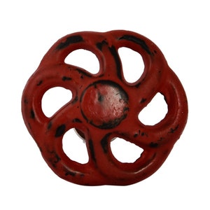 May include: Red metal valve handle with a distressed finish. The handle has a circular shape with five spokes and a central hole.