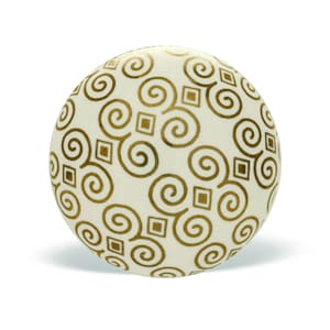 May include: White round ornament with a gold swirl and square pattern.