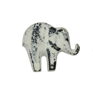 May include: A white ceramic elephant figurine with black accents. The elephant has a distressed finish, giving it a vintage look.
