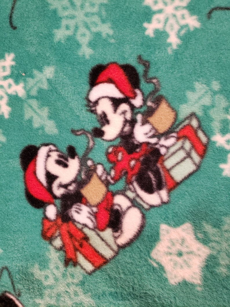 K&ouml;nnte beinhalten: Zwei Comic-M&auml;use mit Weihnachtsm&uuml;tzen, die Geschenke auf einem gr&uuml;nen Hintergrund mit wei&szlig;en Schneeflocken halten.