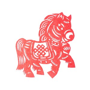 May include: A red paper cut-out of a horse, a traditional Chinese folk art. The horse has intricate details, including a saddle with a geometric design and a flowing mane and tail. The horse is depicted in a side profile against a white background.