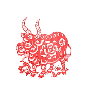 May include: A red paper cut-out of a bull, a symbol of the Chinese zodiac. The bull features intricate floral and swirl patterns, with curved horns and detailed legs. The artwork is set against a white background.