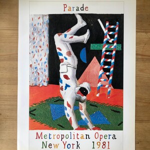 Op de afbeelding: Een kleurrijke poster voor de Metropolitan Opera in New York uit 1981. Het kunstwerk toont een figuur in een wit pak met rode en blauwe vlekken die een handstand doet. Een ladder en geometrische vormen zijn ook inbegrepen.
