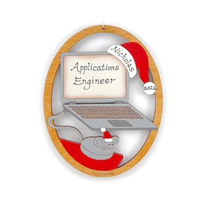 May include: A wooden Christmas ornament shaped like a laptop computer with a mouse and a Santa hat. The laptop screen says "Applications Engineer" and the ornament is personalized with the name "Nicholas" and the year "2022".