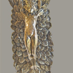 Può includere: Una scultura in bronzo di una figura nuda con una corona di foglie, circondata da un design dettagliato di foglie sovrapposte.