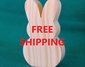 May include: A light brown wooden bunny ornament. The bunny is cut out and stands upright. The words "FREE SHIPPING" are printed in red across the image.