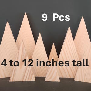 May include: Nine wooden mountain-shaped decorations, ranging from 4 to 12 inches tall. The natural wood pieces are arranged against a dark background. The text "9 Pcs" and "4 to 12 inches tall" are displayed in white.