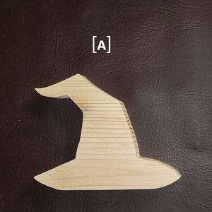May include: A wooden witch hat cutout, featuring a classic pointed shape with a wide brim. The hat is made of light-colored wood, with visible grain patterns. The letter "A" is in the upper left corner. Perfect for Halloween crafts.