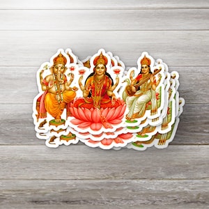 Puede incluir: Una pila de pegatinas con deidades hindúes. Las pegatinas representan a Ganesha, Lakshmi y Saraswati en colores vibrantes. Ganesha se muestra con una cabeza de elefante, Lakshmi sentada en un loto y Saraswati tocando una veena.