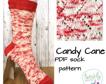 Peut inclure: Une chaussette tricotée avec un motif de canne en bonbon, utilisant du fil rouge et blanc. Le bord et le bout du pied sont rouge uni. Le design comprend un gros plan du motif tricoté et le texte "Candy Cane PDF sock pattern".
