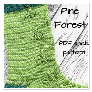May include: A knitted sock pattern with the text "Pine Forest PDF sock pattern." The sock features a green and white striped design with small tree-like details. The cuff and heel are a darker shade of green.