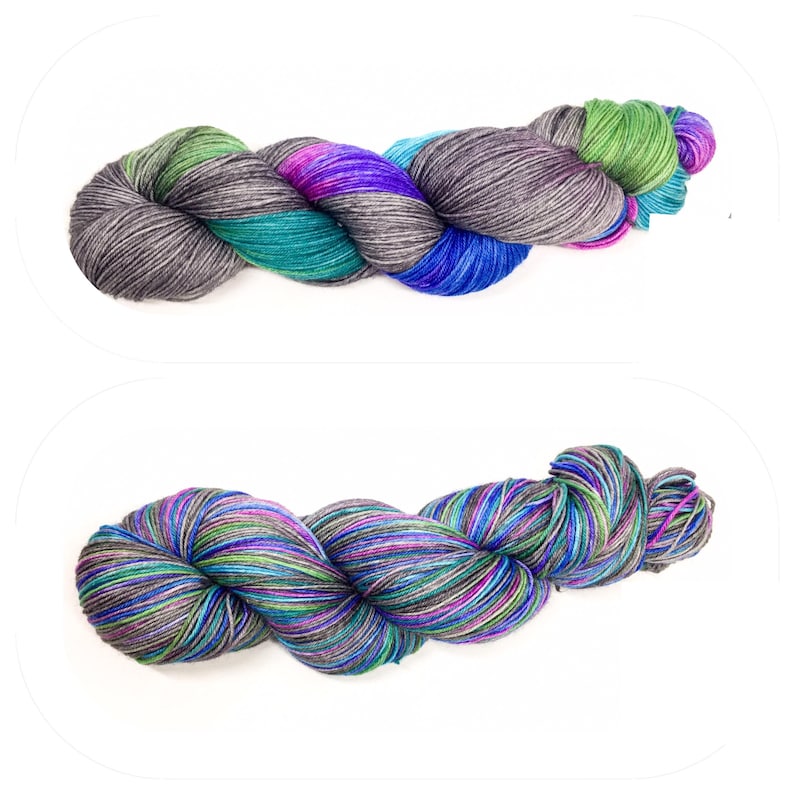 Puede incluir: Dos ovillos de hilo en un patr&oacute;n multicolor de azul, verde, morado y gris. El hilo est&aacute; dispuesto en una bobina suelta.
