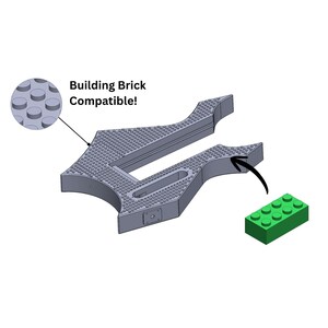 Könnte beinhalten: Eine graue, mit Bausteinen kompatible, dekorative Basis mit strukturierter Oberfläche und einem grünen Baustein. Der Text "Building Brick Compatible!" ist ebenfalls im Bild.