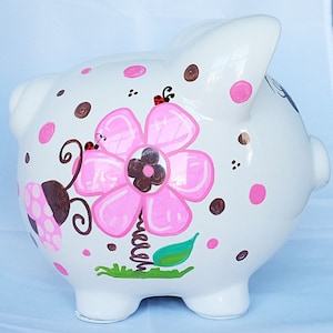 Personalisiertes handbemaltes Sparschwein für Mädchen mit Blumen & Marienkäfer Design - Geschenk für Kinder