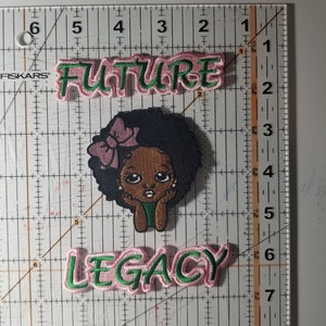 May include: Pink and green embroidered patches with the words "FUTURE" and "LEGACY". A black and brown cartoon girl with a pink bow is in the center of the patches.