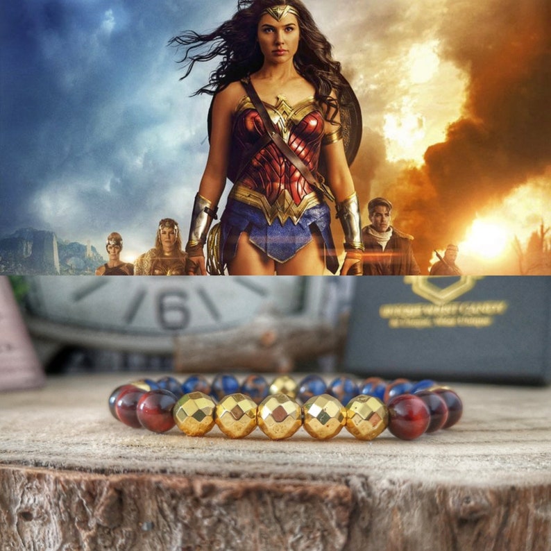 May include: A gold, blue, and red beaded bracelet with a geometric design. The bracelet is made of gold-toned metal beads, blue glass beads, and red tiger's eye beads.