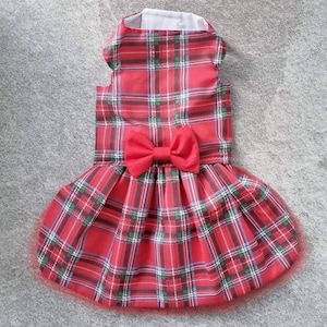 May include: Red plaid dog dress with a red bow. The dress has a sleeveless bodice and a full skirt.