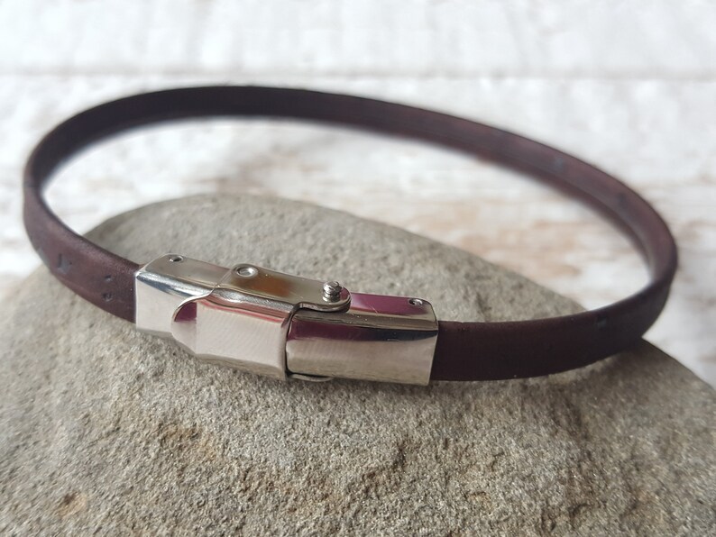 May include: A brown leather bracelet with a silver clasp.