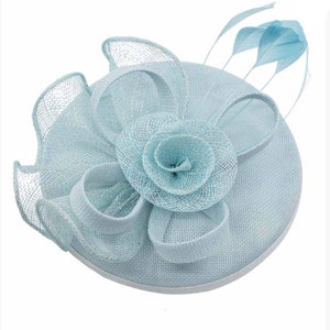 May include: A light blue fascinator hat with a large flower made of netting and a few feathers.