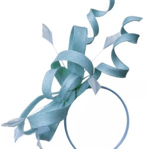 May include: A light blue headpiece with a woven texture, featuring looped ribbons and decorative white feathers. The headpiece is attached to a thin, matching headband, suitable for special occasions.