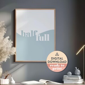 May include: A digital download print of a minimalist poster with a blue and white background and the text "half full". The poster is framed in a light wood frame and is ready to print.