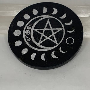 Pode incluir: Copo de pedra circular preto com um pentáculo prateado e um design de fases da lua.