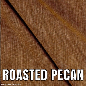 Puede incluir: Primer plano de una tela marr&oacute;n con un pliegue diagonal. La tela tiene un aspecto texturizado y tejido. El texto "ROASTED PECAN" est&aacute; impreso en blanco en la parte inferior de la imagen.