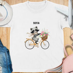 Aangepast T-shirt voor kinderen, schattige wasbeer op fiets met bloemenmand T-shirt, leuk op de natuur geïnspireerd shirt, unieke dierenprint