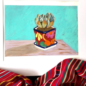 May include: An acrylic painting of a succulent plant in a colorful, patterned pot. The pot is red with orange, yellow, and pink floral designs. The background is a solid turquoise color. The painting is on a white matted surface.